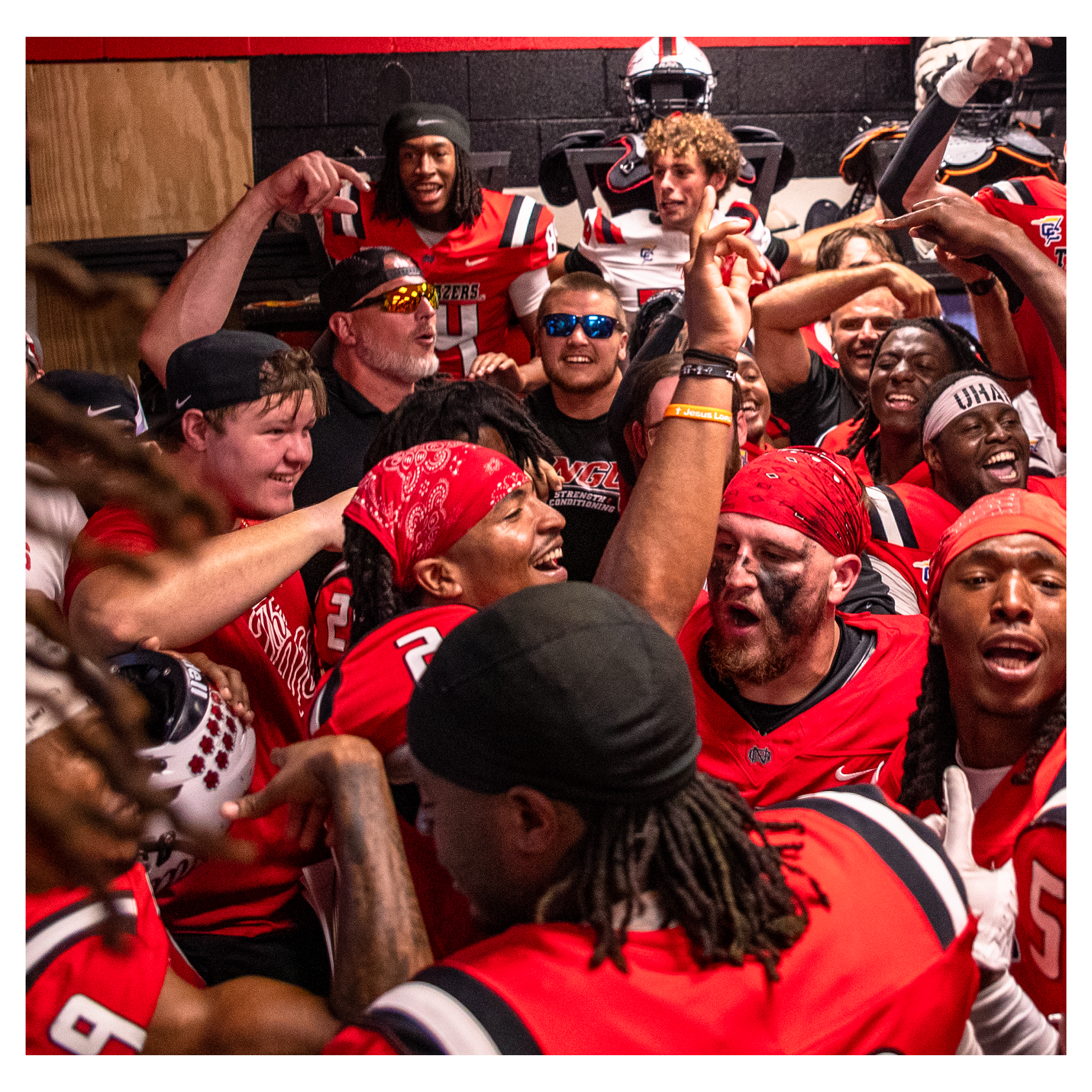 Football team celebrating together in the locker room after a win
