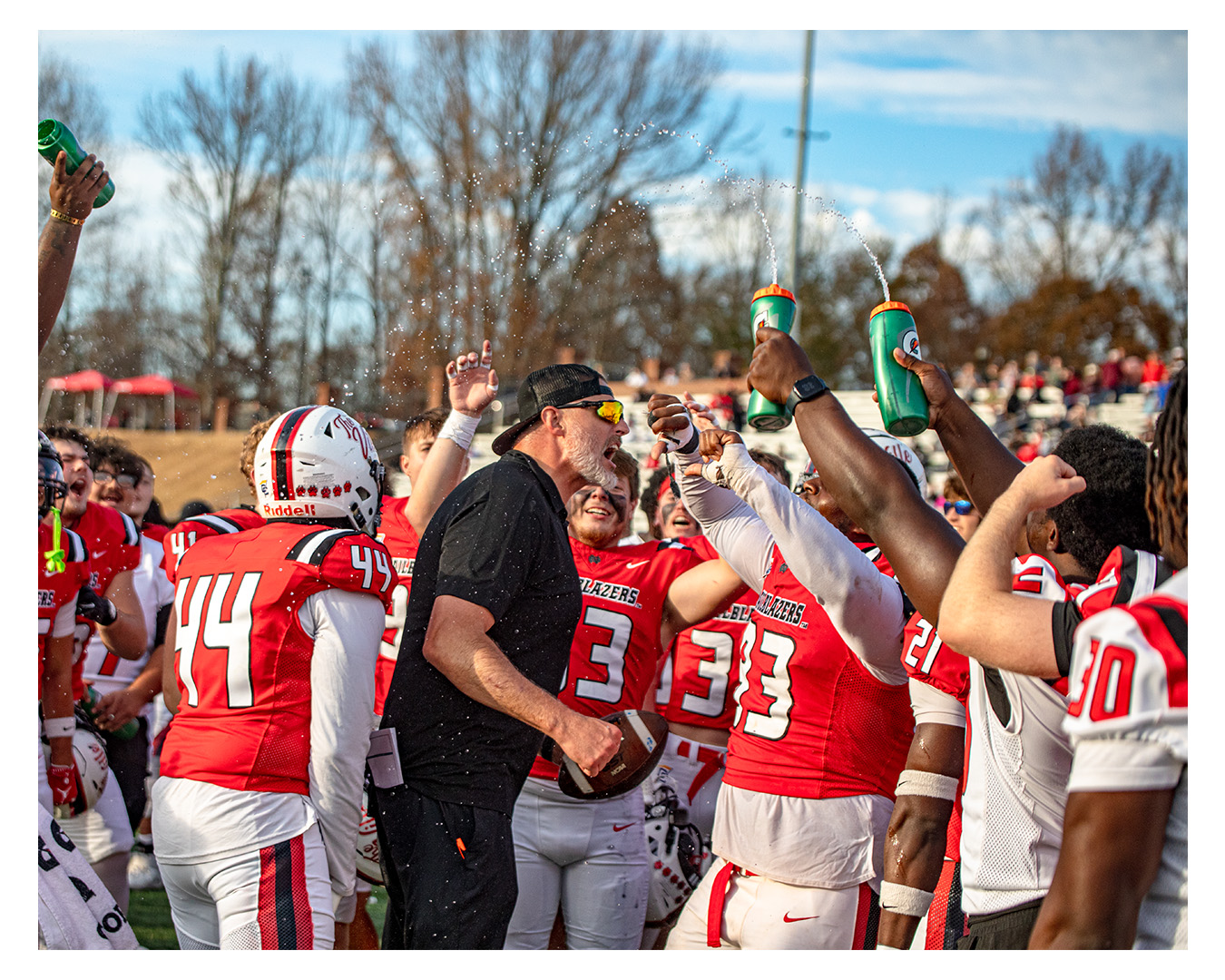Coach Nate celebrating with his football team on the field